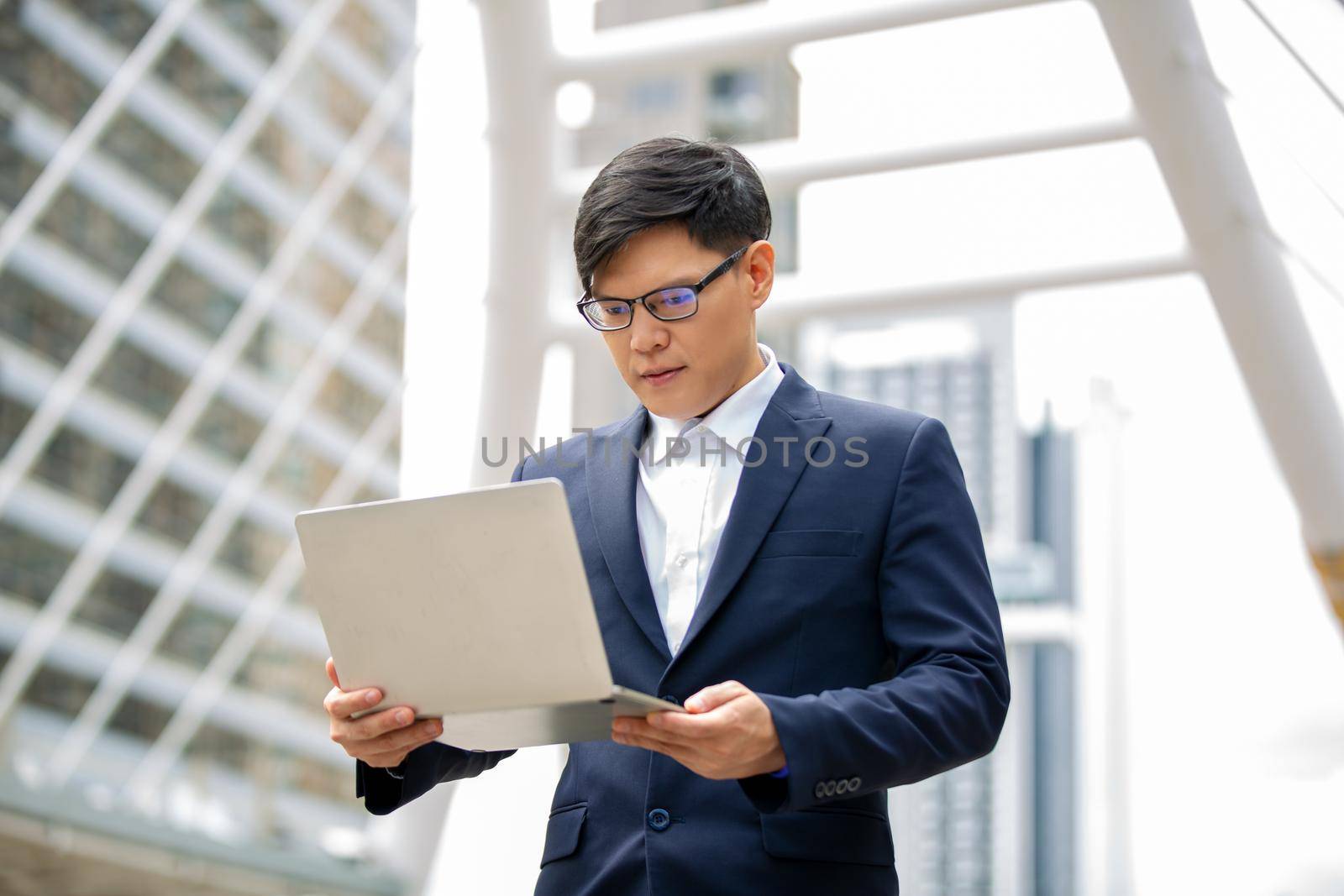 Business person using laptop at outside office.