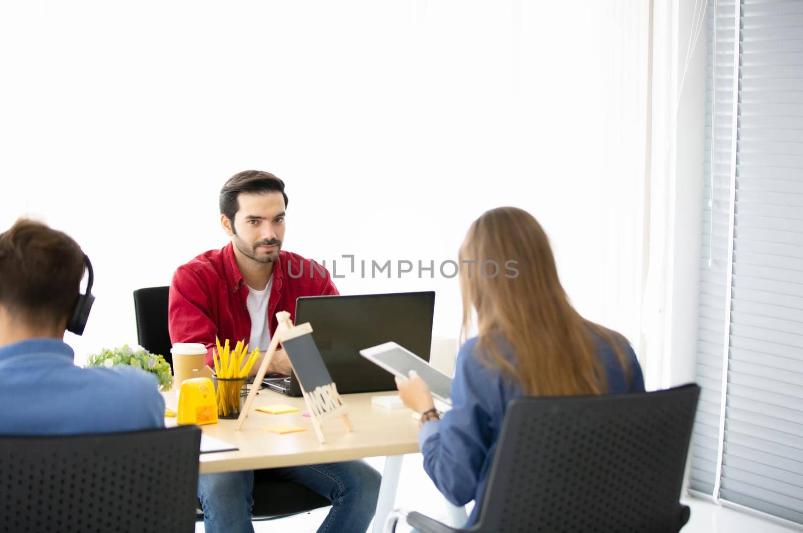 Business people working in office on desktop computer, Group of happy business people in smart casual wear looking at the laptop and gesturing. Achieving success.