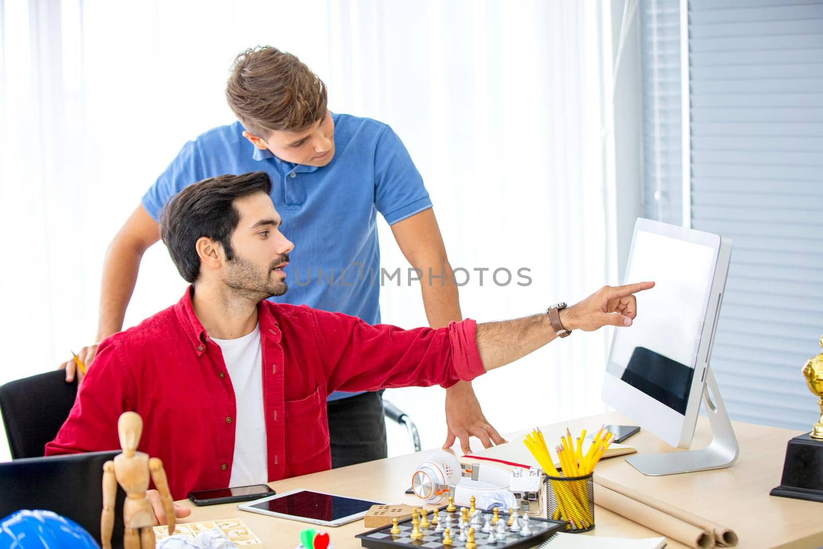 Business people working in office on desktop computer, Group of happy business people in smart casual wear looking at the laptop and gesturing. Achieving success.