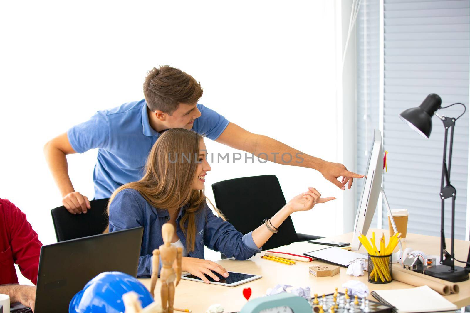 Business people working in office on desktop computer, Group of happy business people in smart casual wear looking at the laptop and gesturing. Achieving success.