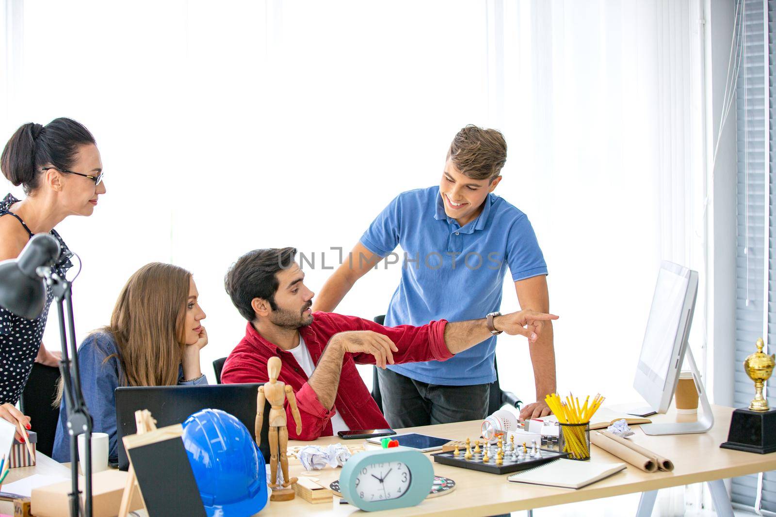 Business people working in office on desktop computer, Group of happy business people in smart casual wear looking at the laptop and gesturing. Achieving success.