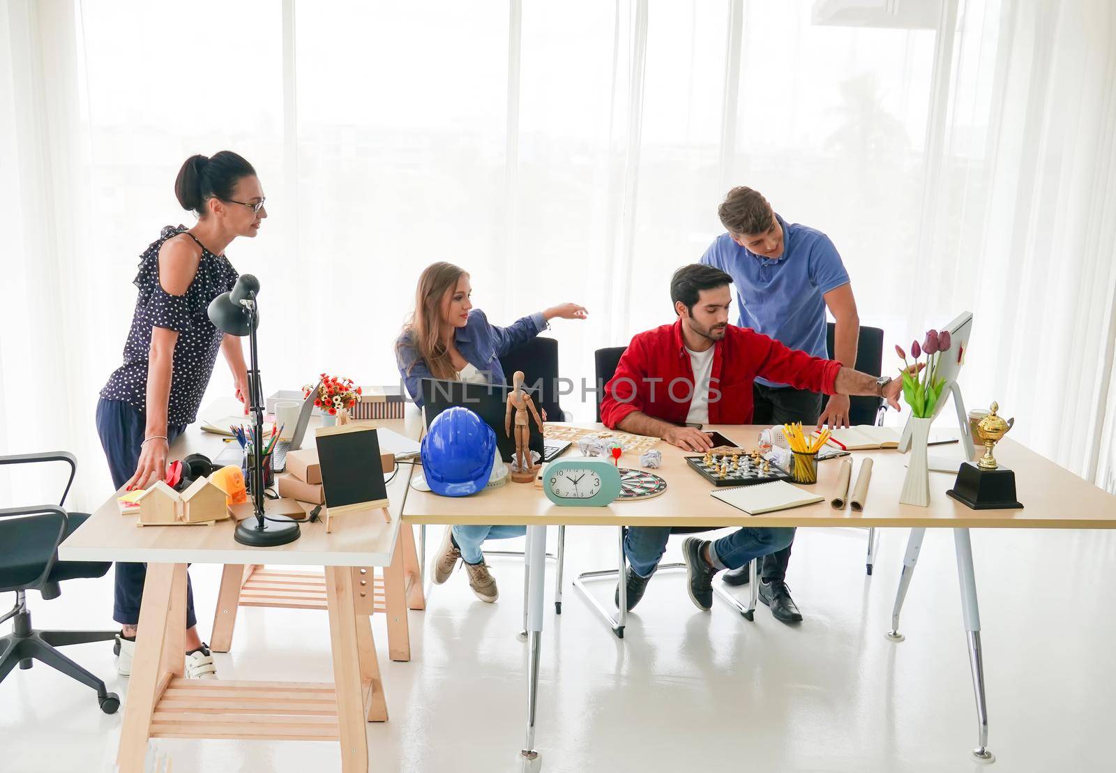 Business people working in office on desktop computer, Group of happy business people in smart casual wear looking at the laptop and gesturing. Achieving success.