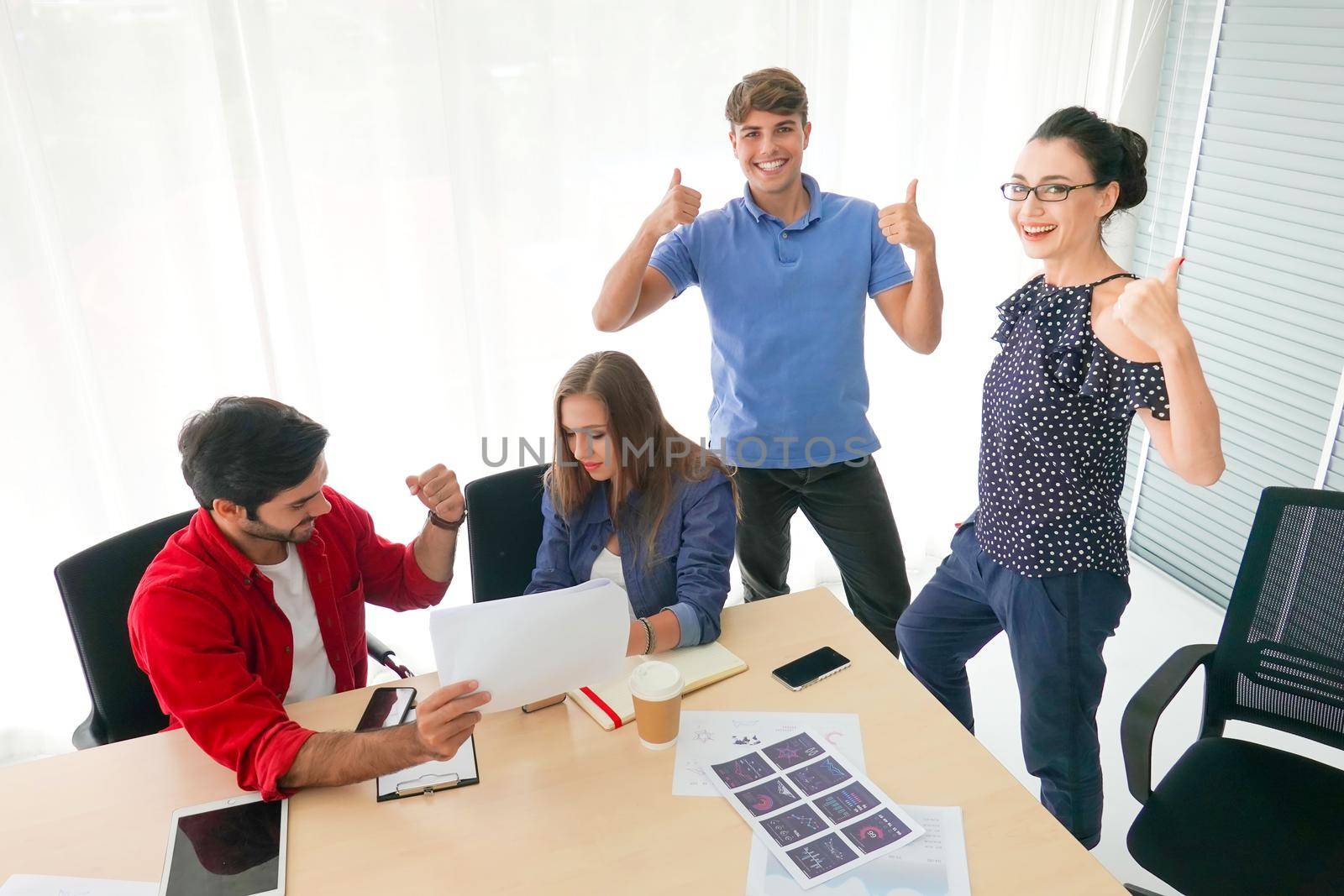 Business people working in office on desktop computer, Group of happy business people in smart casual wear looking at the laptop and gesturing. Achieving success. by chuanchai