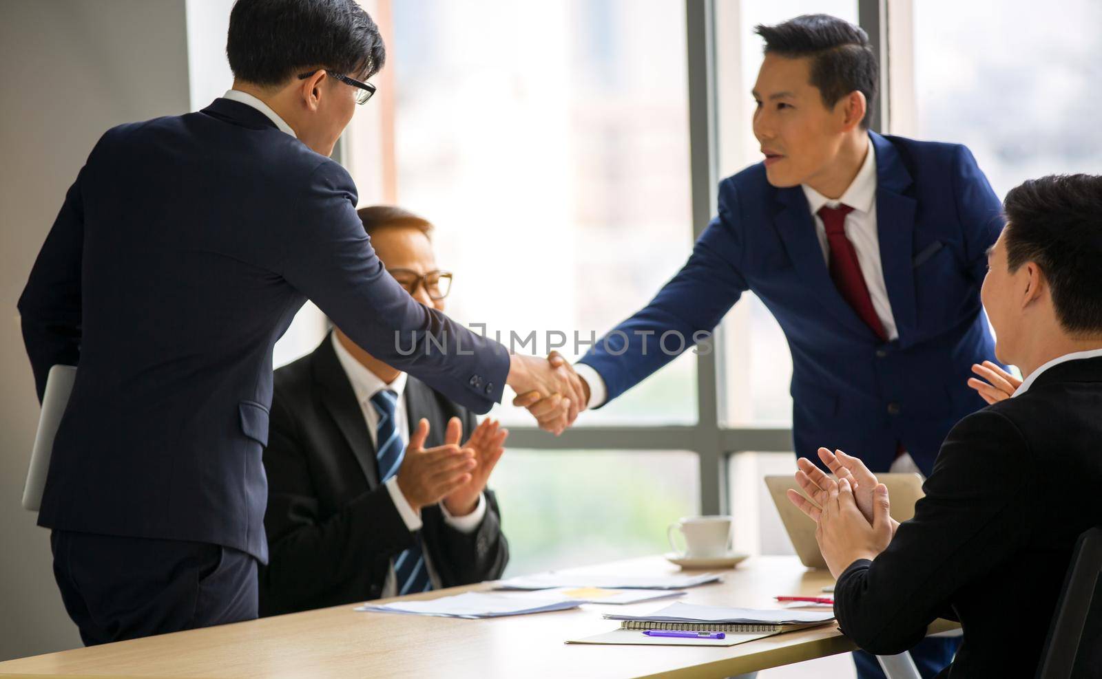 Business people shaking hands in the modern office finishing successful meeting