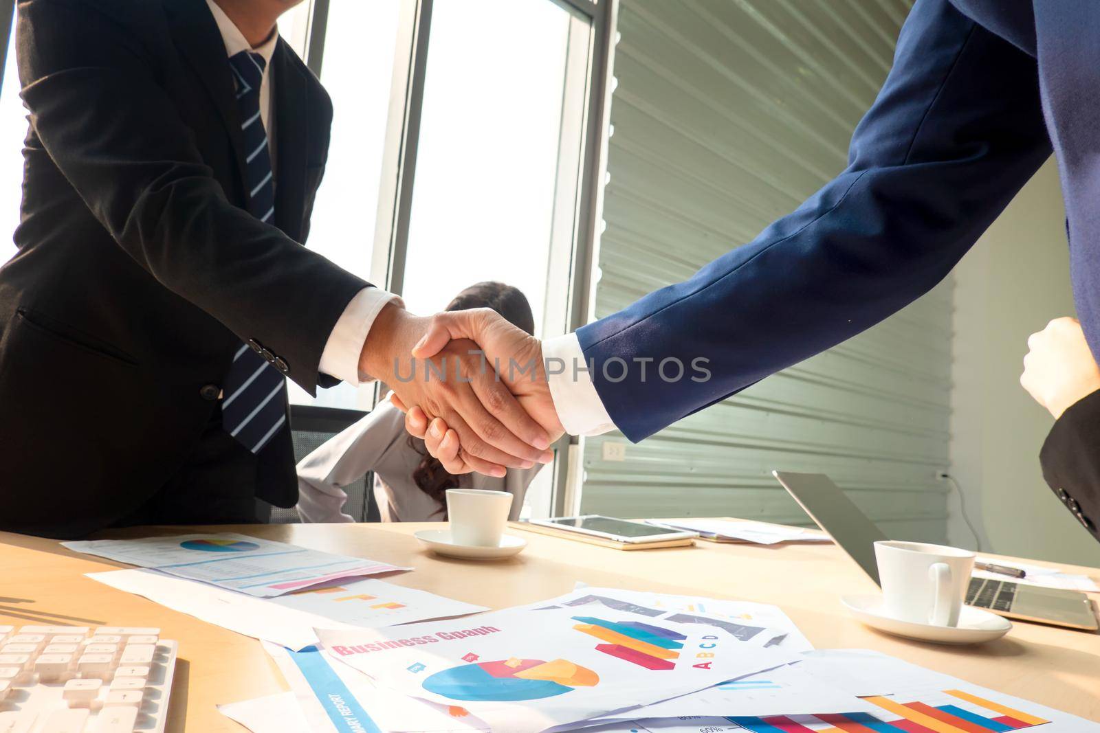 Business people shaking hands in the modern office finishing successful meeting by chuanchai