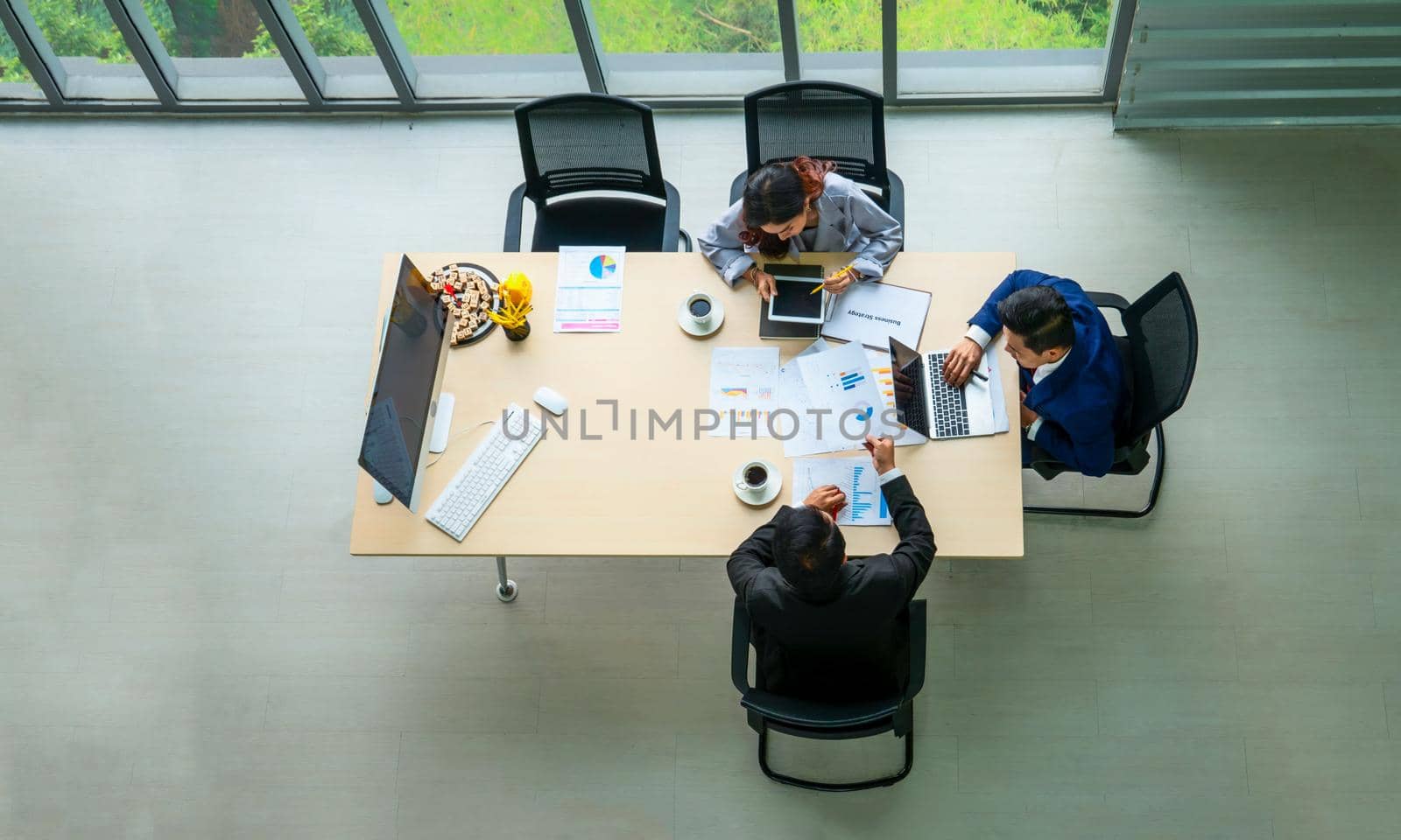 Top view on a group of businessman and businesswoman having a meeting and making a business commitment. by chuanchai