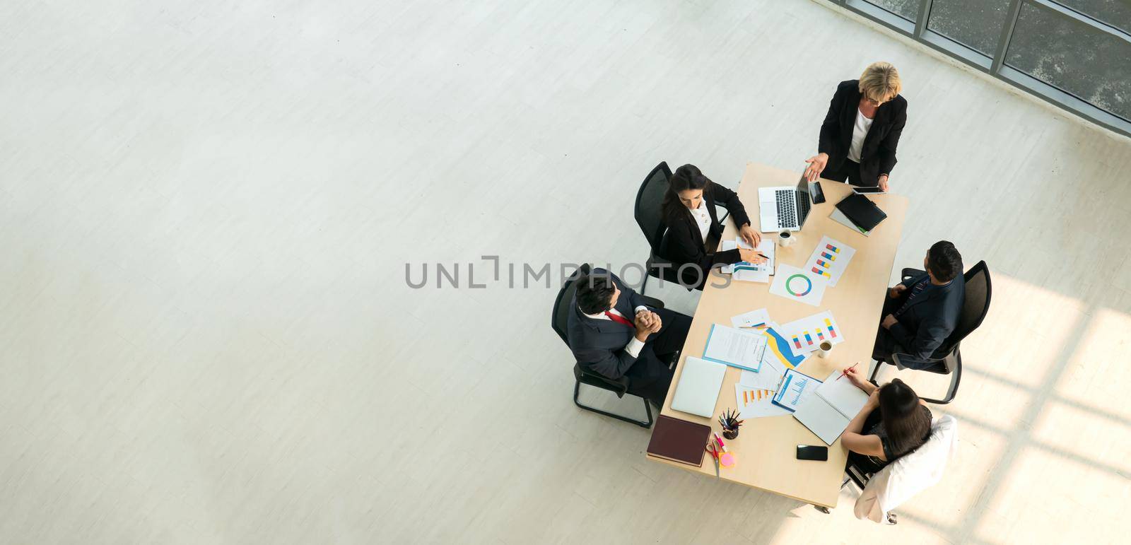 Top view on a group of businessman and businesswoman having a meeting and making a business commitment. by chuanchai