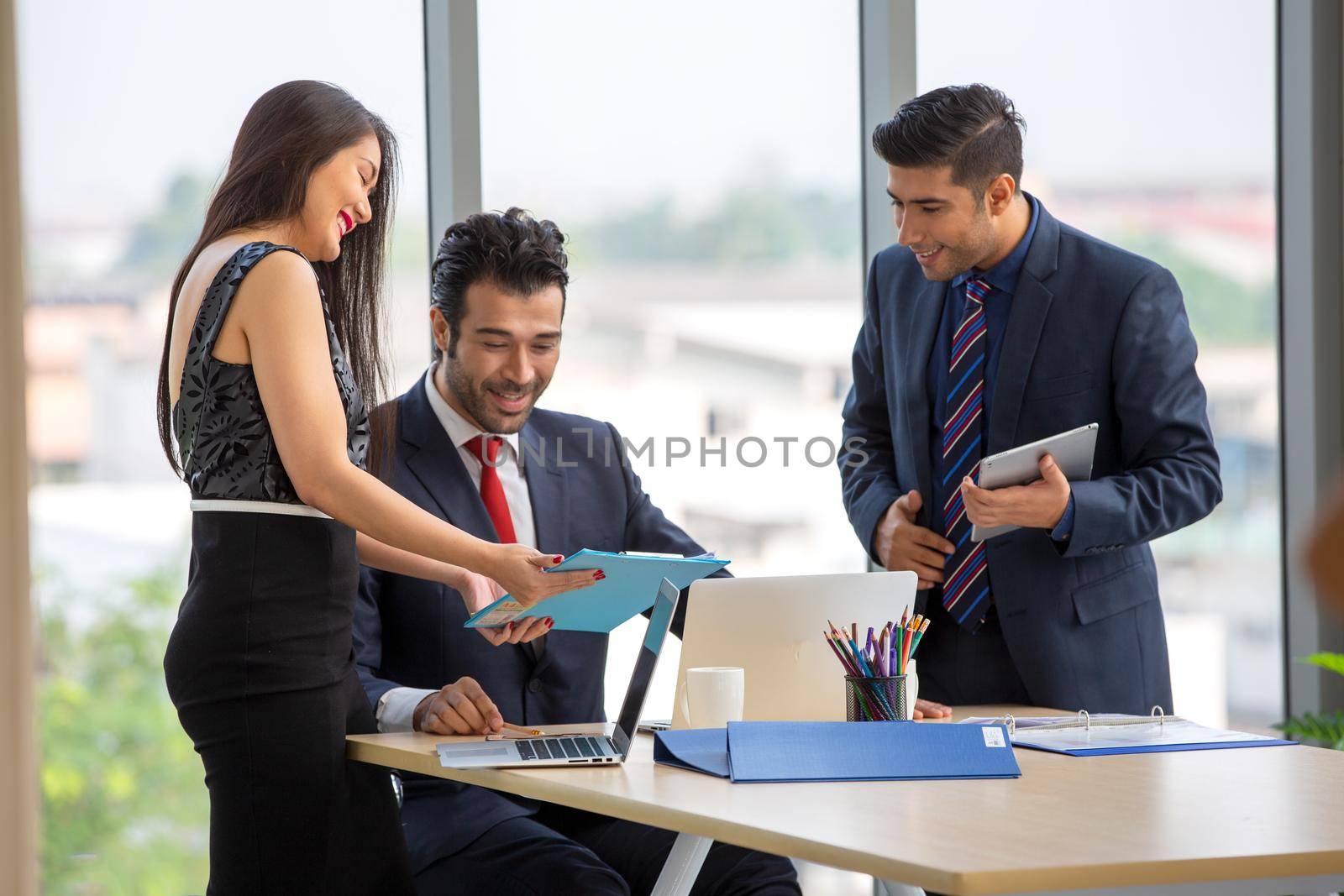 young business team working together at office. Manager pointing at a chart and explaining the analysis about business strategies. Top view shot of business hand shake