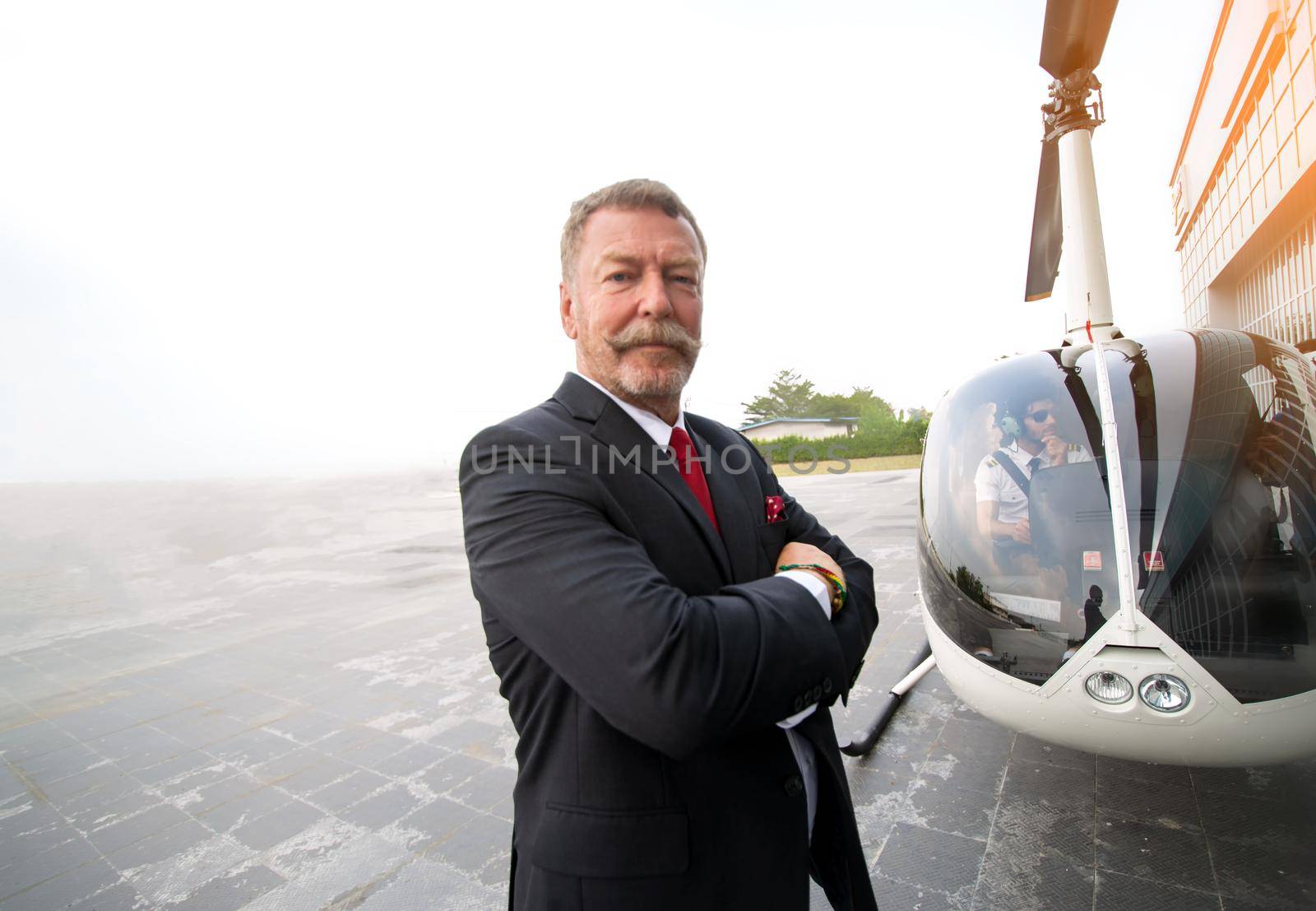 Business people traveling by helicopter , Shot of a mature businessman using a headset while traveling in a helicopter