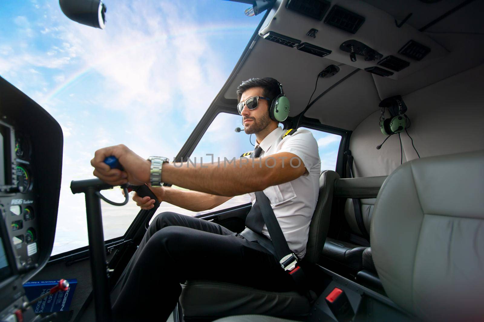 Shot of a mature Helicopter pilot using a headset while traveling in a helicopter, Business people traveling by helicopter