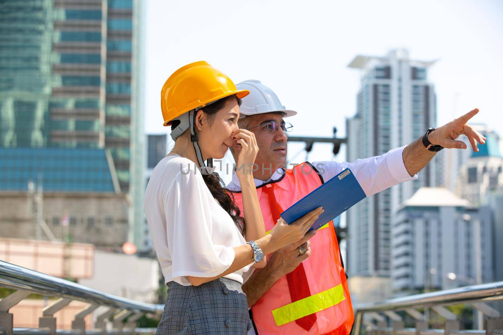 The engineer and business people hand high five against building. The concept of engineering, construction, city life and future.