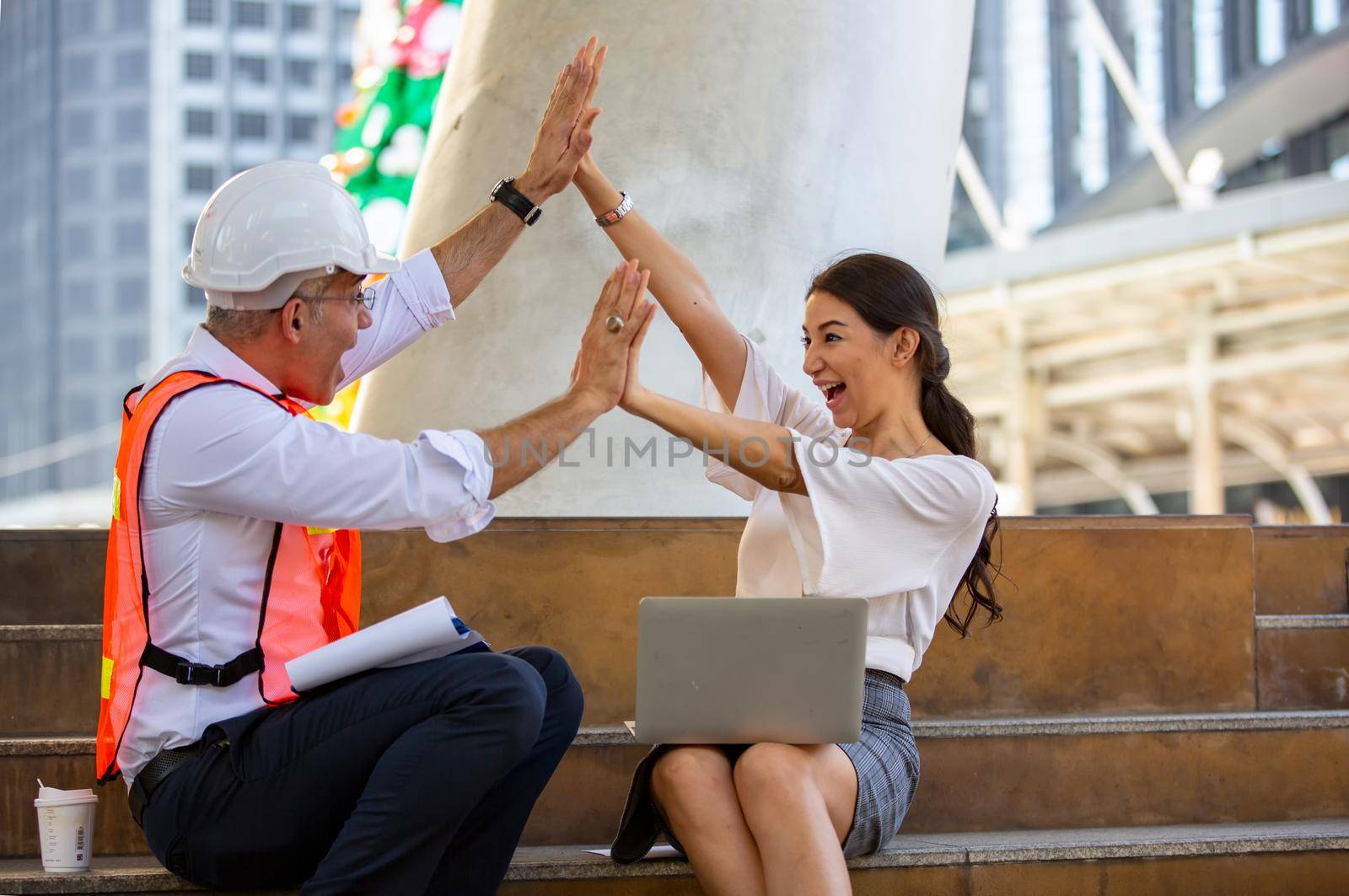 The engineer and business people hand high five against building. The concept of engineering, construction, city life and future. by chuanchai