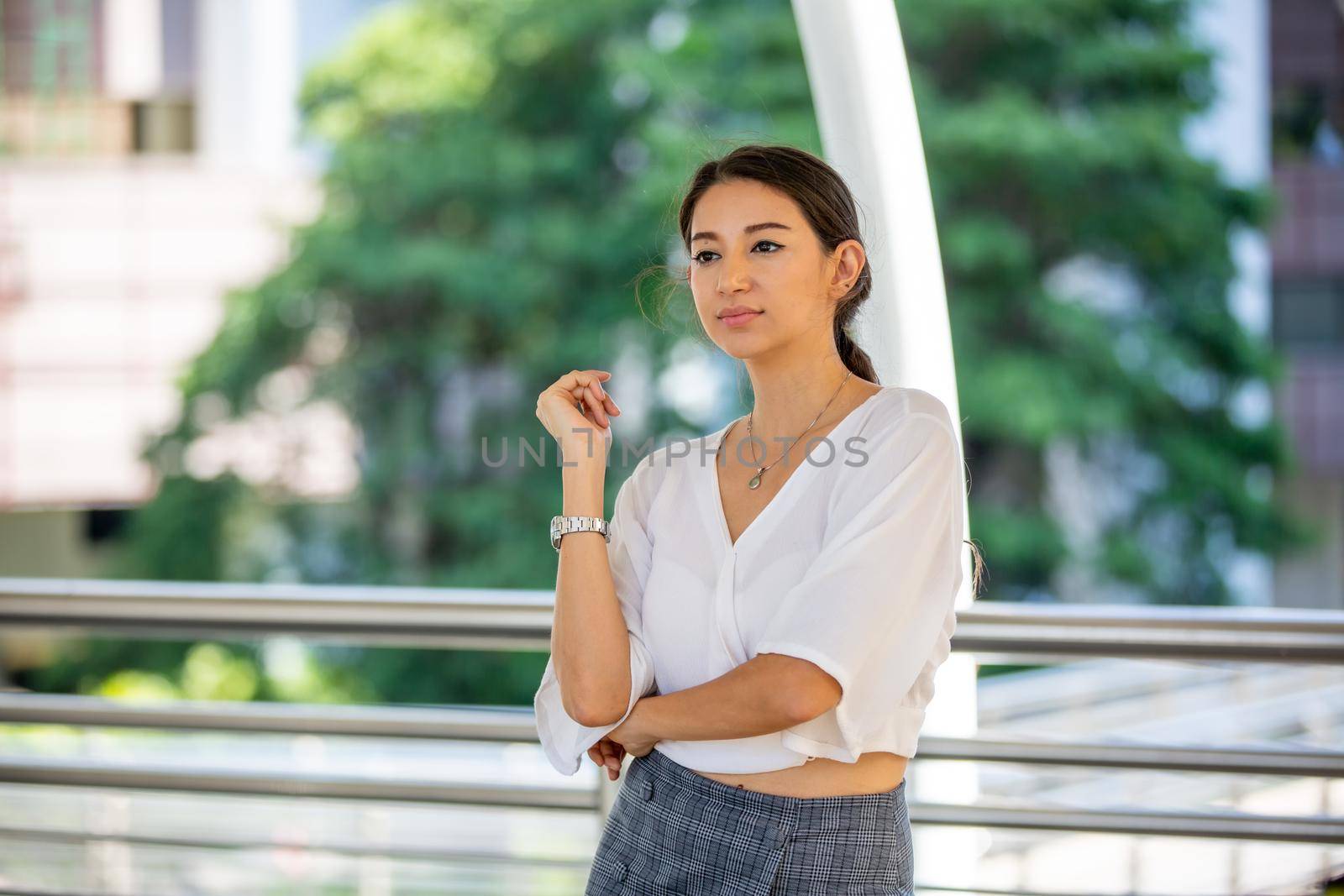 Portrait of young beautiful business woman at outside. Crossed arms