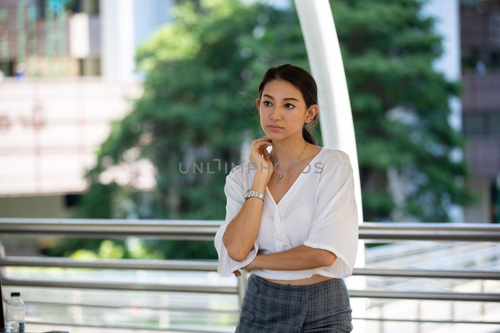 Portrait of young beautiful business woman at outside. Crossed arms