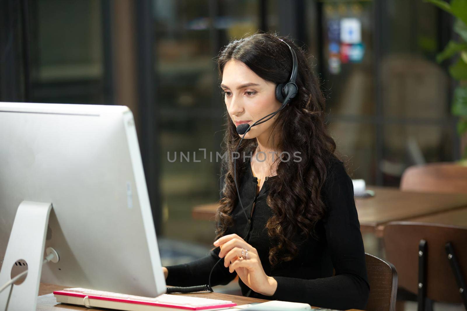 side view.the call center operator and her colleagues work in the office.