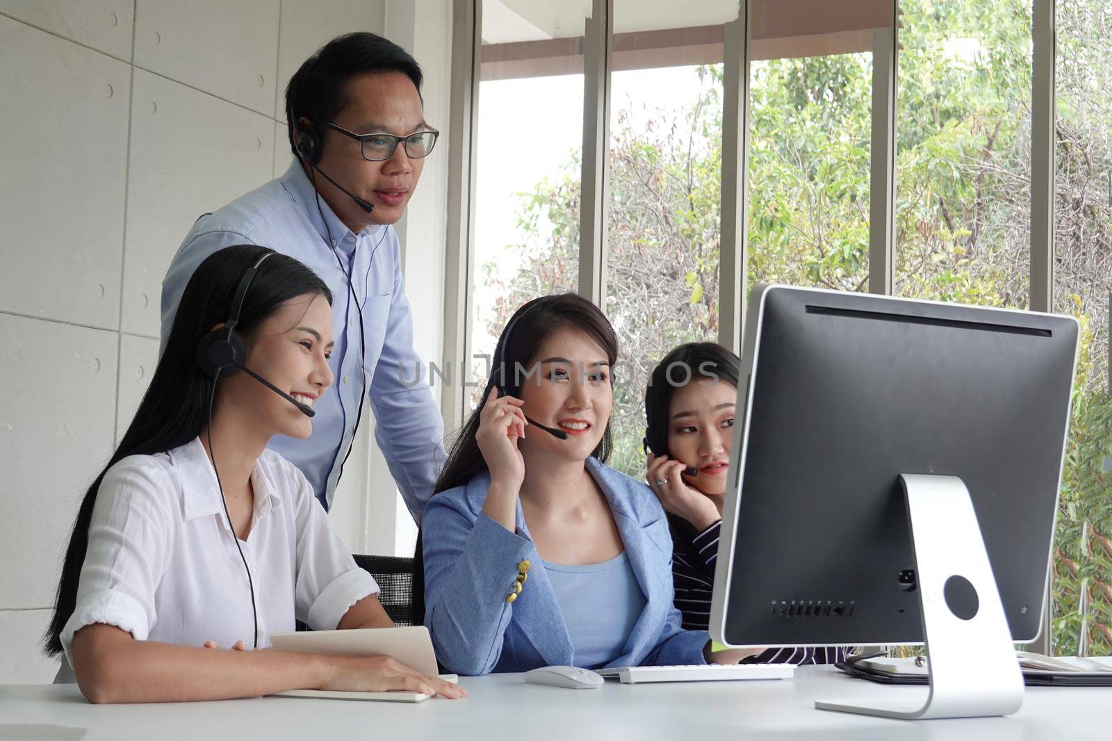 Call center operator in headset while consulting client. Telemarketing or phone sales. Customer service and business concept.