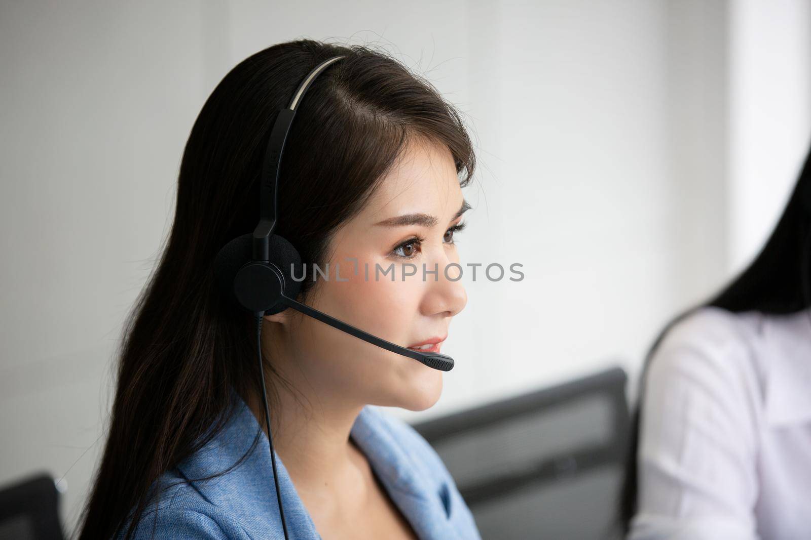 Call center operator in headset while consulting client. Telemarketing or phone sales. Customer service and business concept. by chuanchai