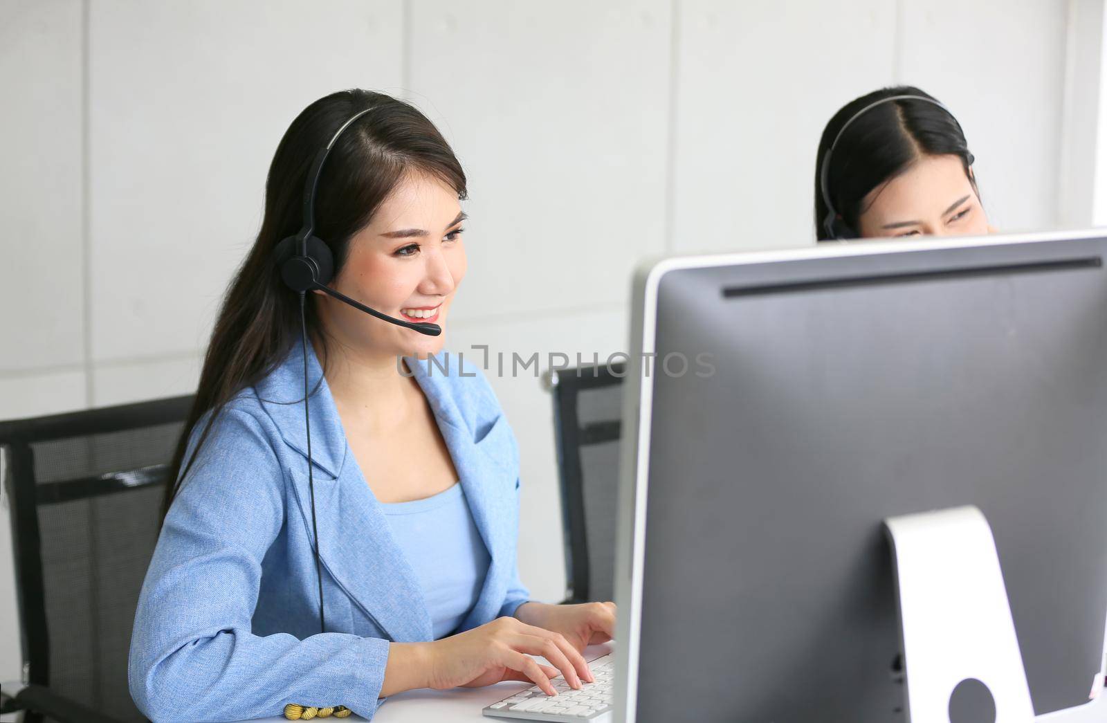 Call center operator in headset while consulting client. Telemarketing or phone sales. Customer service and business concept. by chuanchai