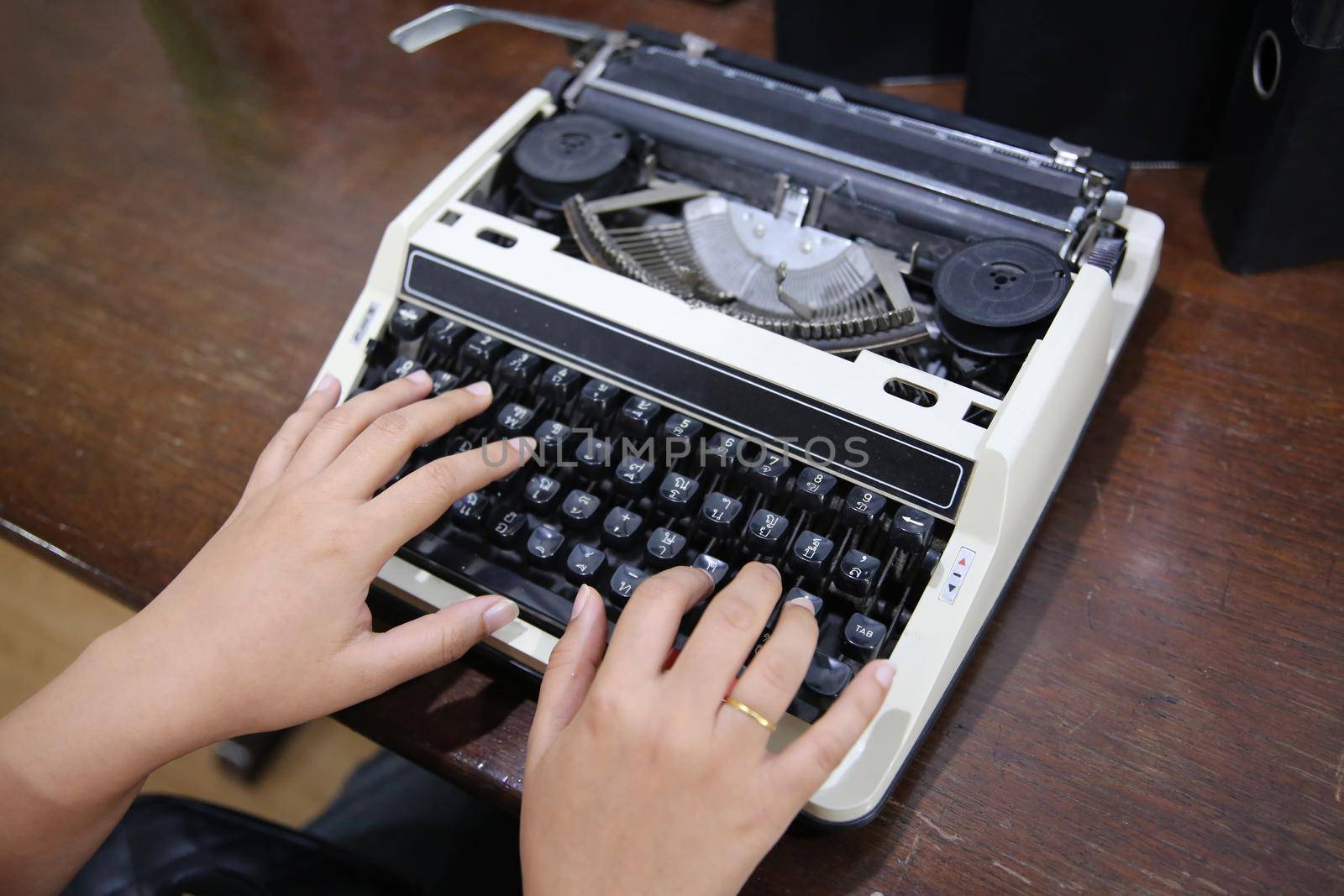 Close-up on women hand typing on type writer. by chuanchai