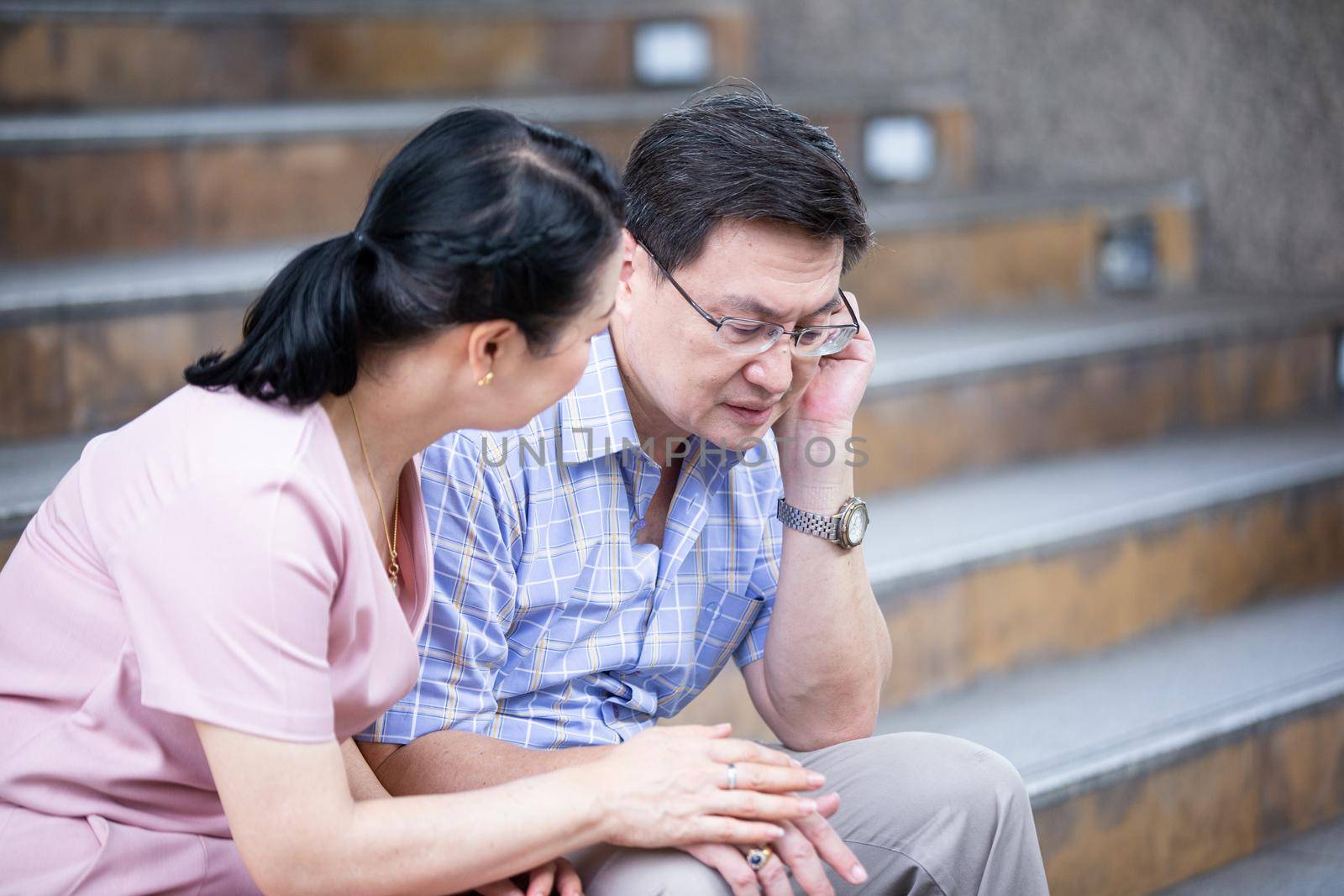 couple elderly sitting on staircase at outdoor. by chuanchai