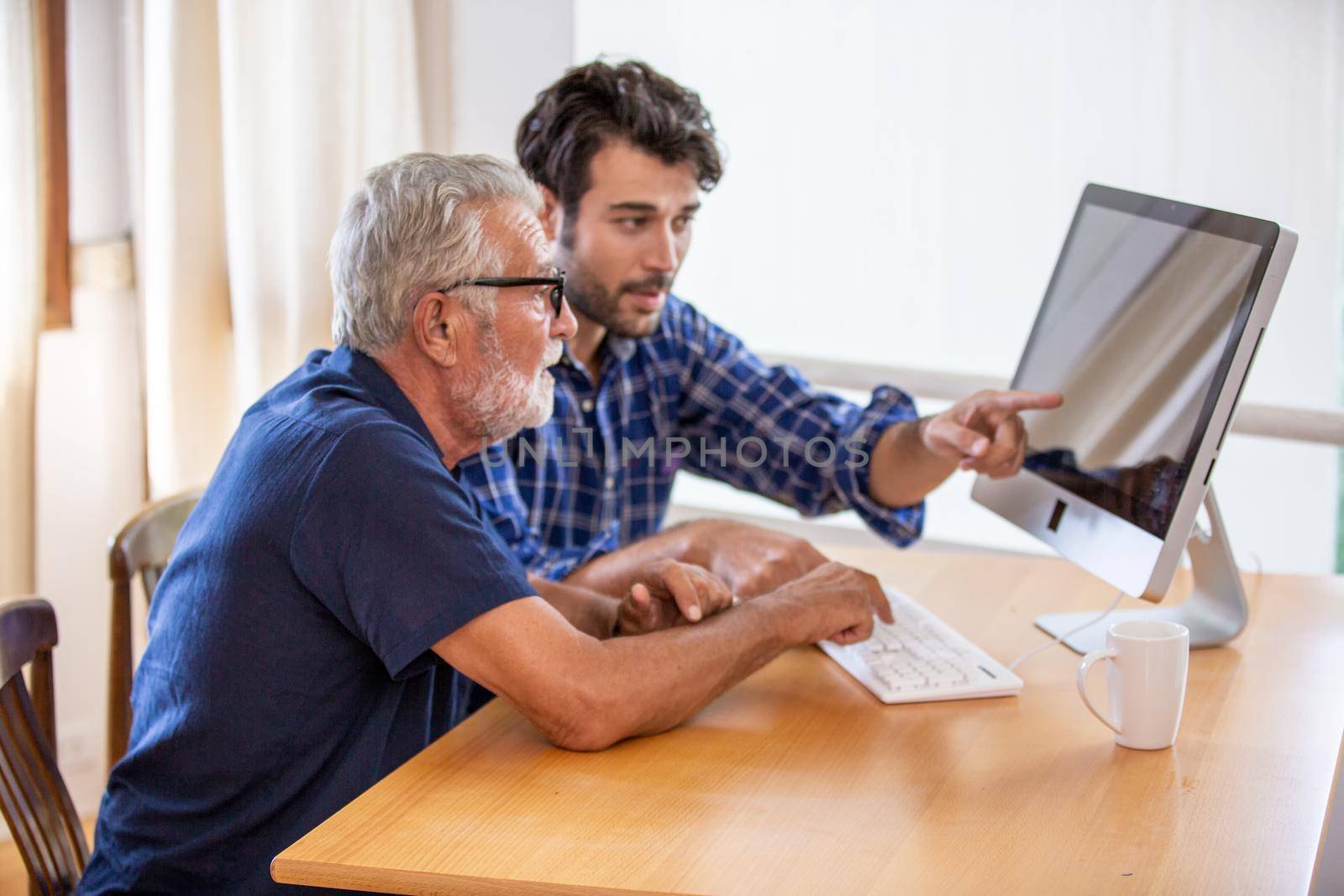 man teaching elderly man to using computer by chuanchai