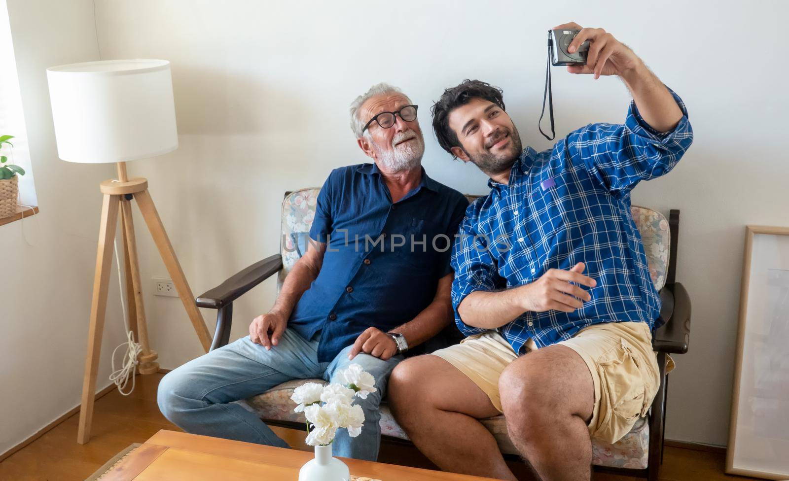 Hipster man taking care about his elderly father in house.