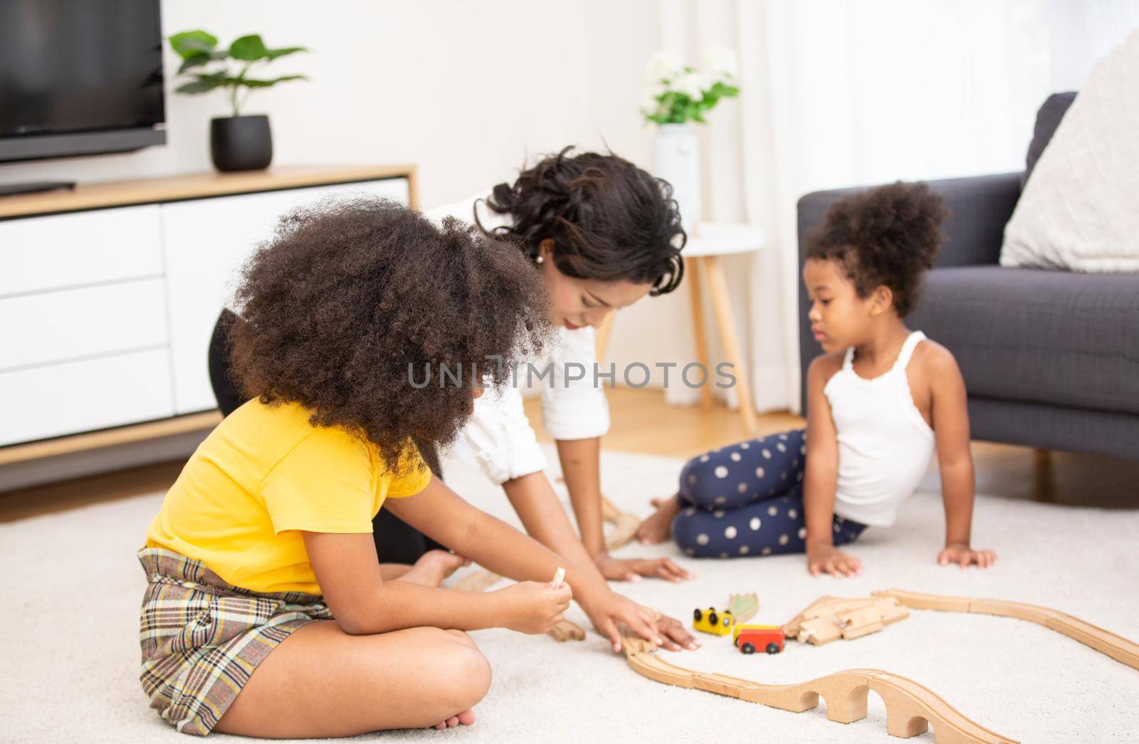 Mix race of family, dad, mom and daughters play together in living room