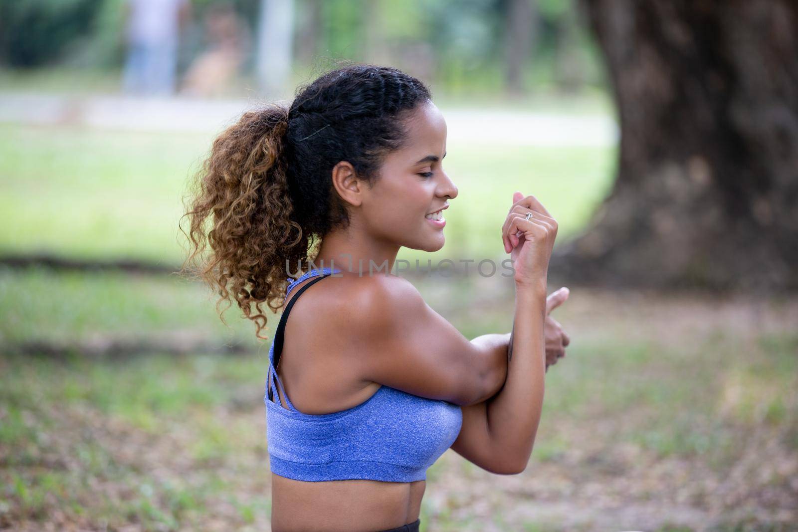 Young attractive smiling woman practicing yoga pose, working out, wearing sportswear pants, bra, full length, outdoor.