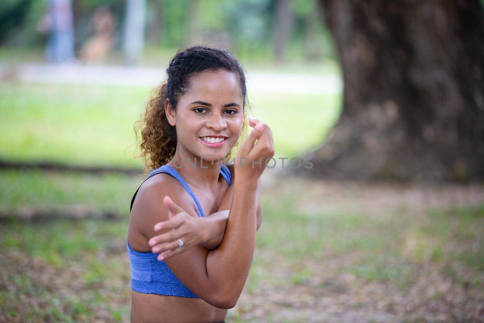 Young attractive smiling woman practicing yoga pose, working out, wearing sportswear pants, bra, full length, outdoor. by chuanchai