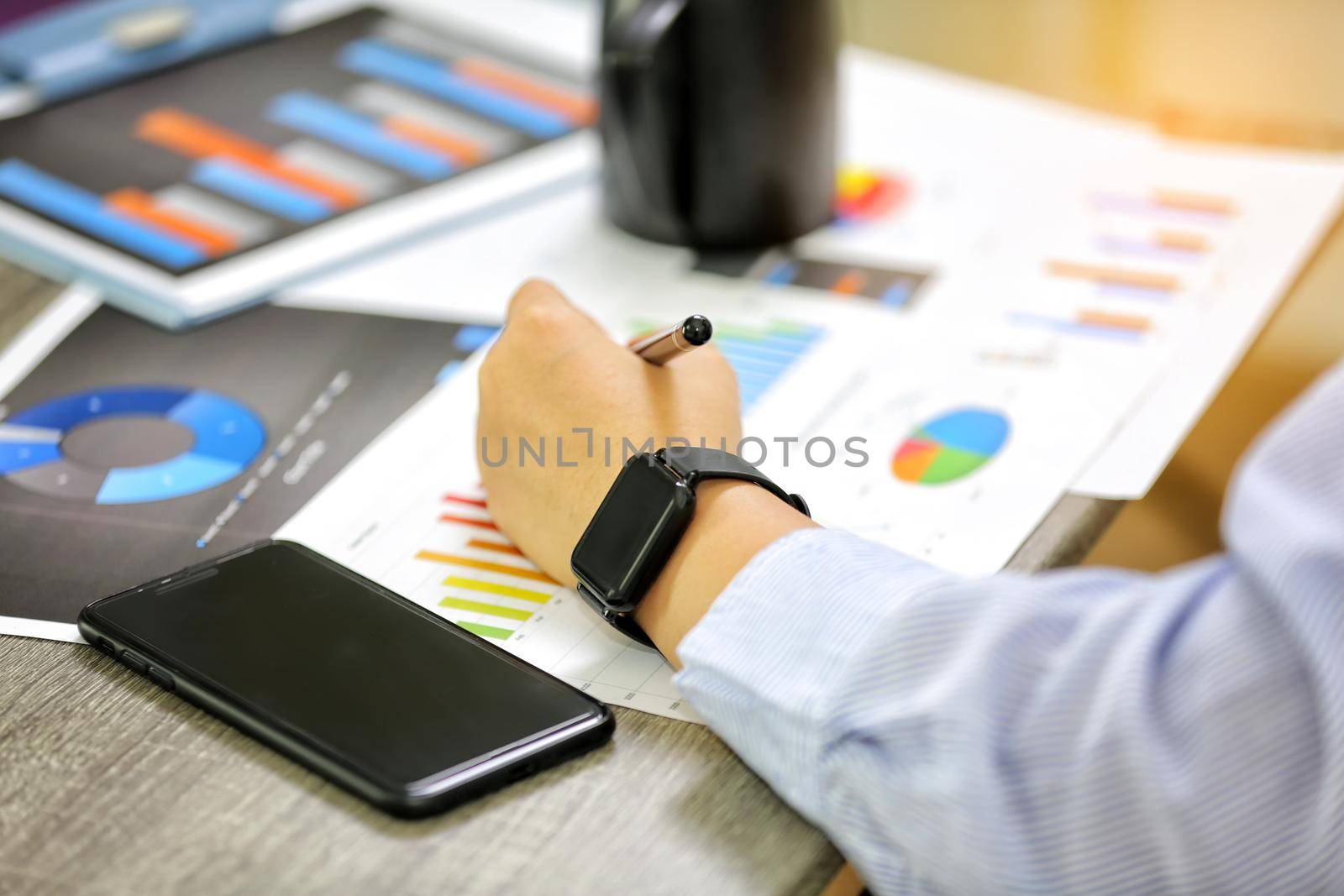 High Angle View Of Graph Papers On Table and business people writing on paperwork by chuanchai