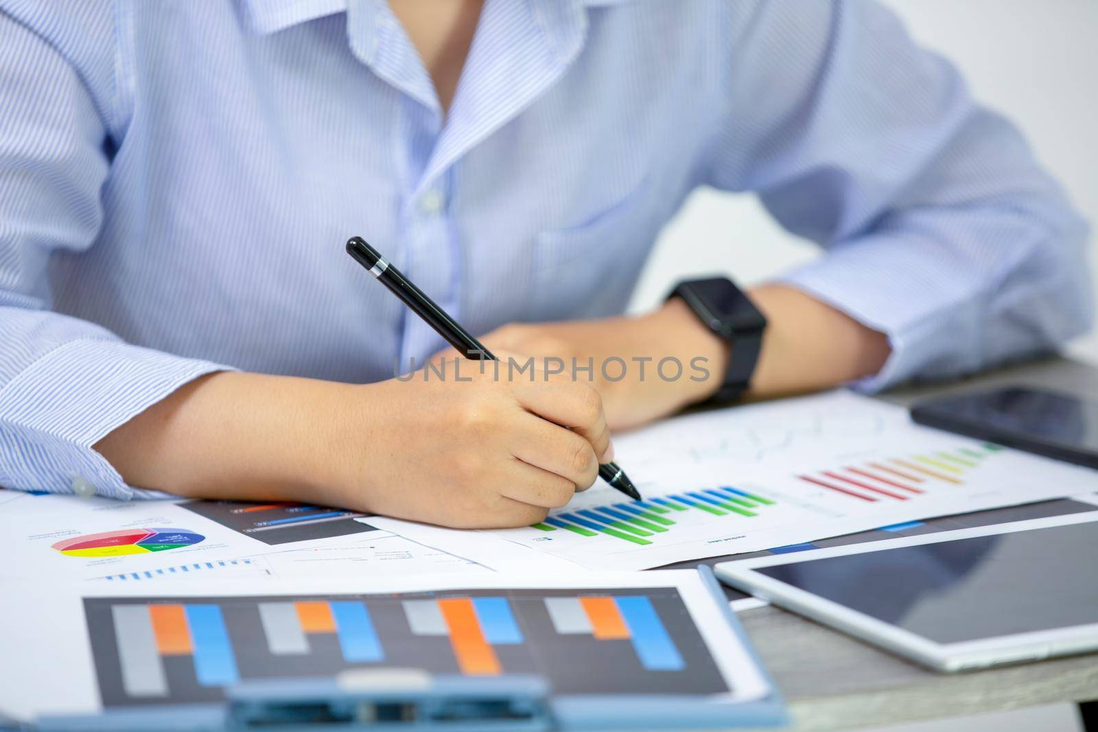 High Angle View Of Graph Papers On Table and business people writing on paperwork
