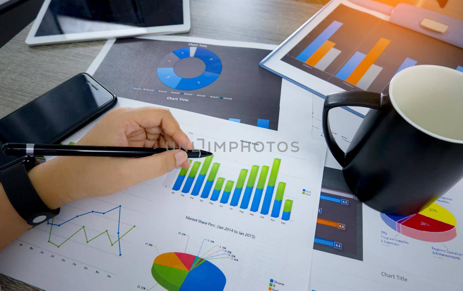 High Angle View Of Graph Papers On Table and business people writing on paperwork