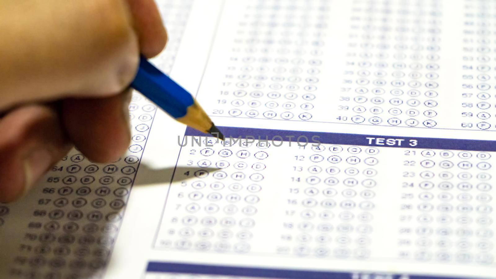 close up on pencils writing on examination paper.