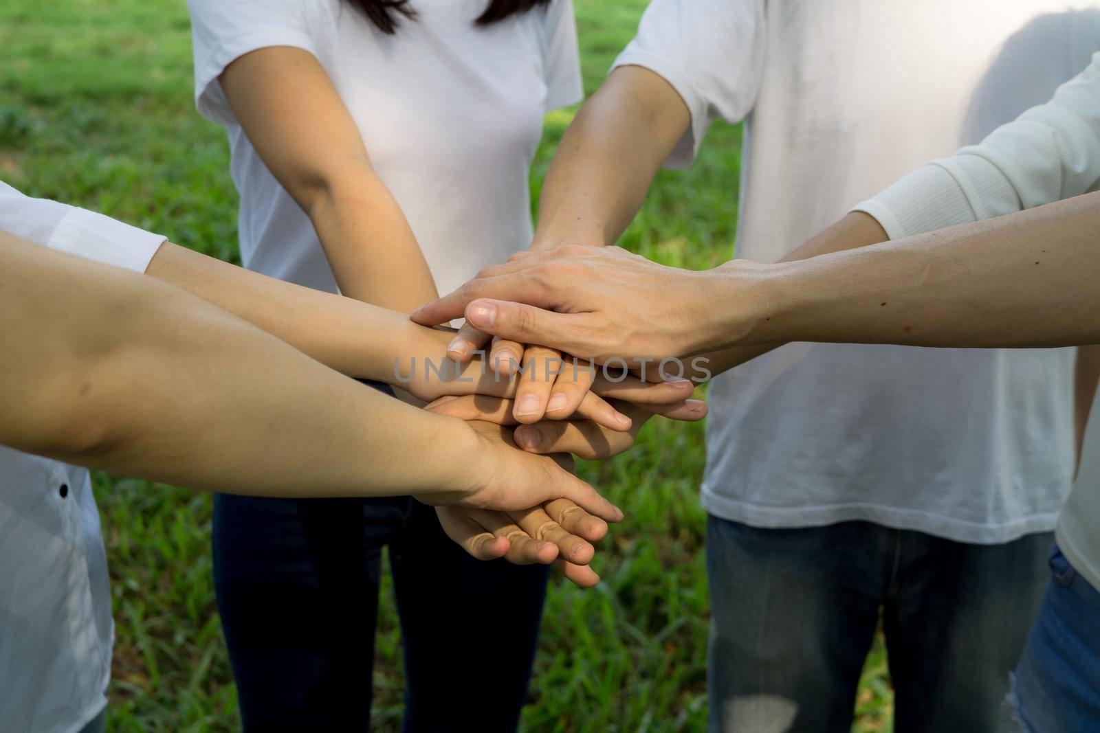 people give hands stack or holding each other for Unity and teamwork concept.