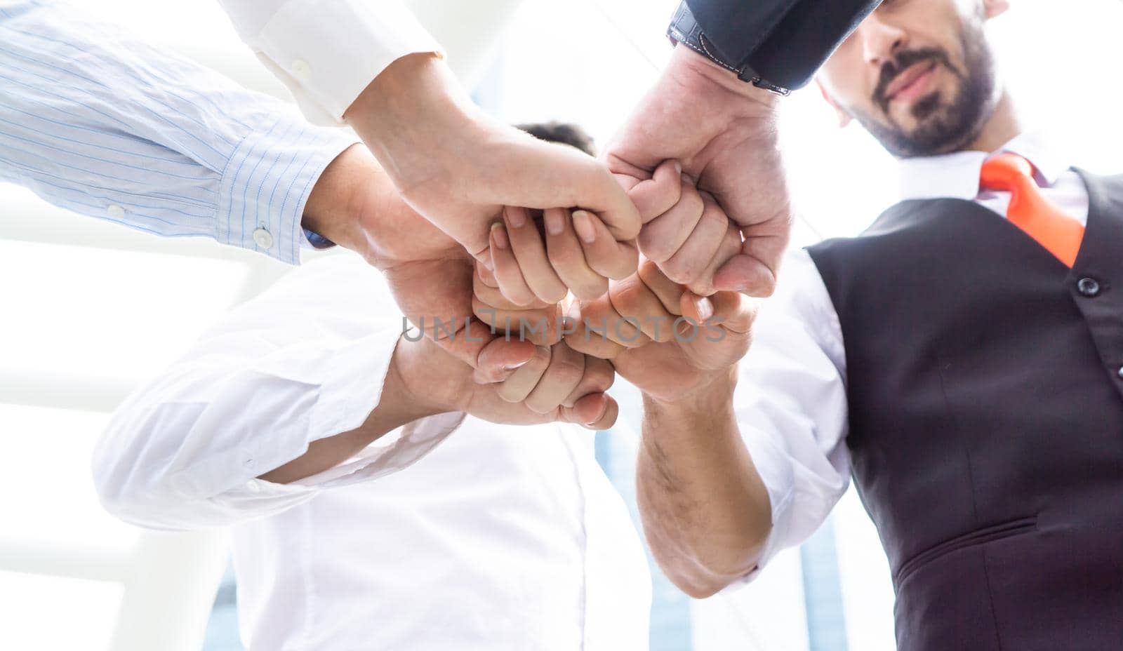 Close up top view of young business people putting their hands together. Stack of hands. Unity and teamwork concept.
