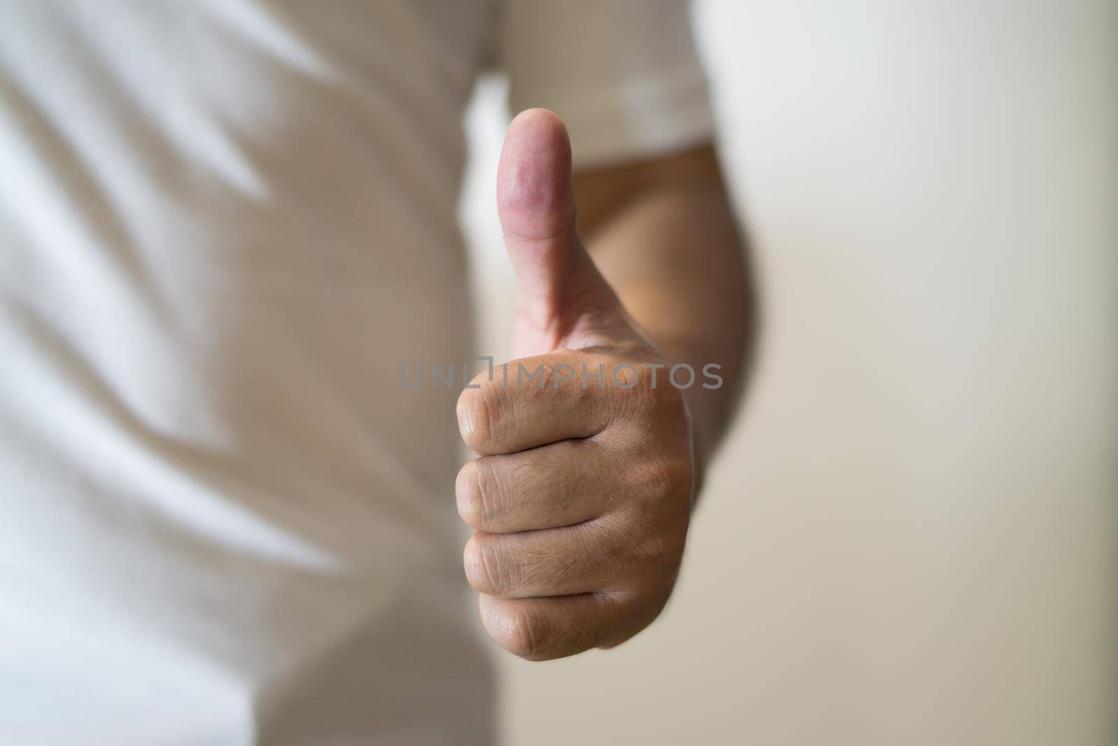 Close up of thumb up against white background.
