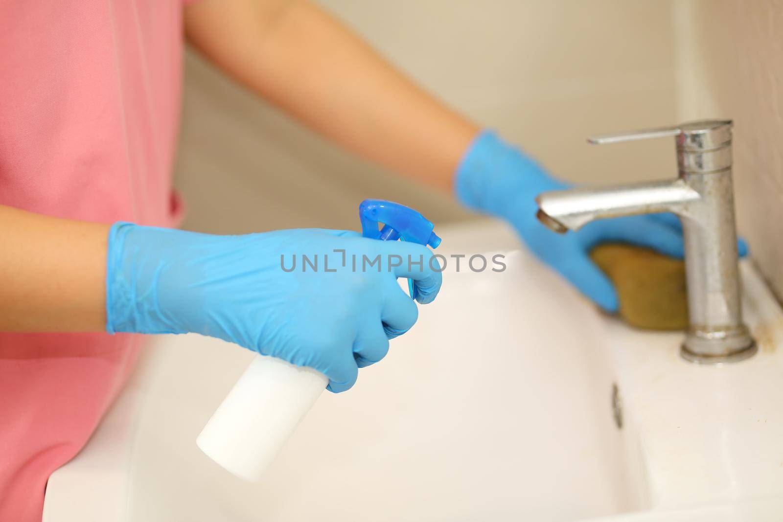 a hand in a blue rubber glove in the picture, removes and washes bathroom sink