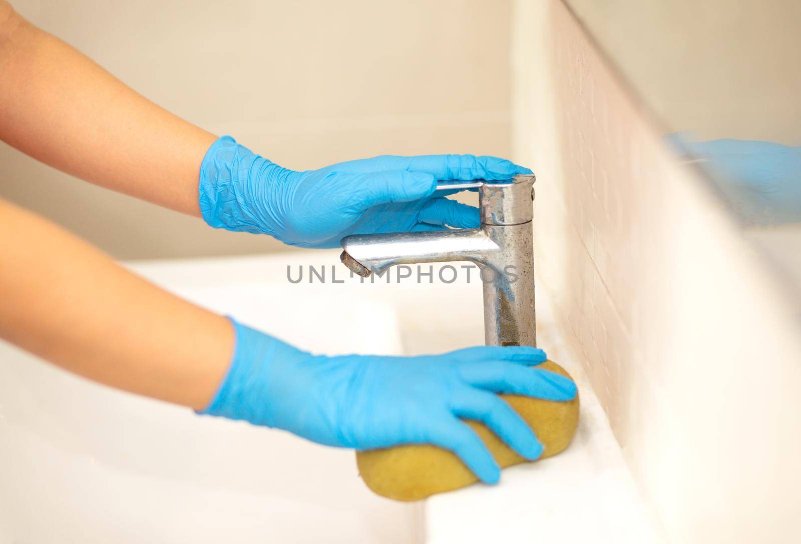 a hand in a blue rubber glove in the picture, removes and washes bathroom sink by chuanchai
