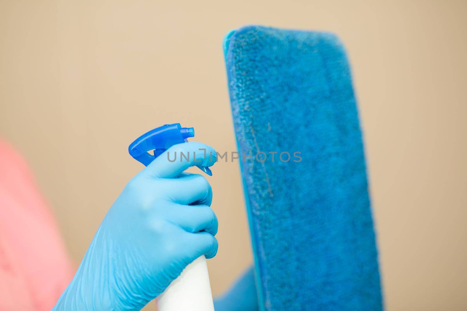 Close-up women hand in a blue rubber glove and cleaning spong in the picture, removes and washes bathroom sink and mirror. by chuanchai