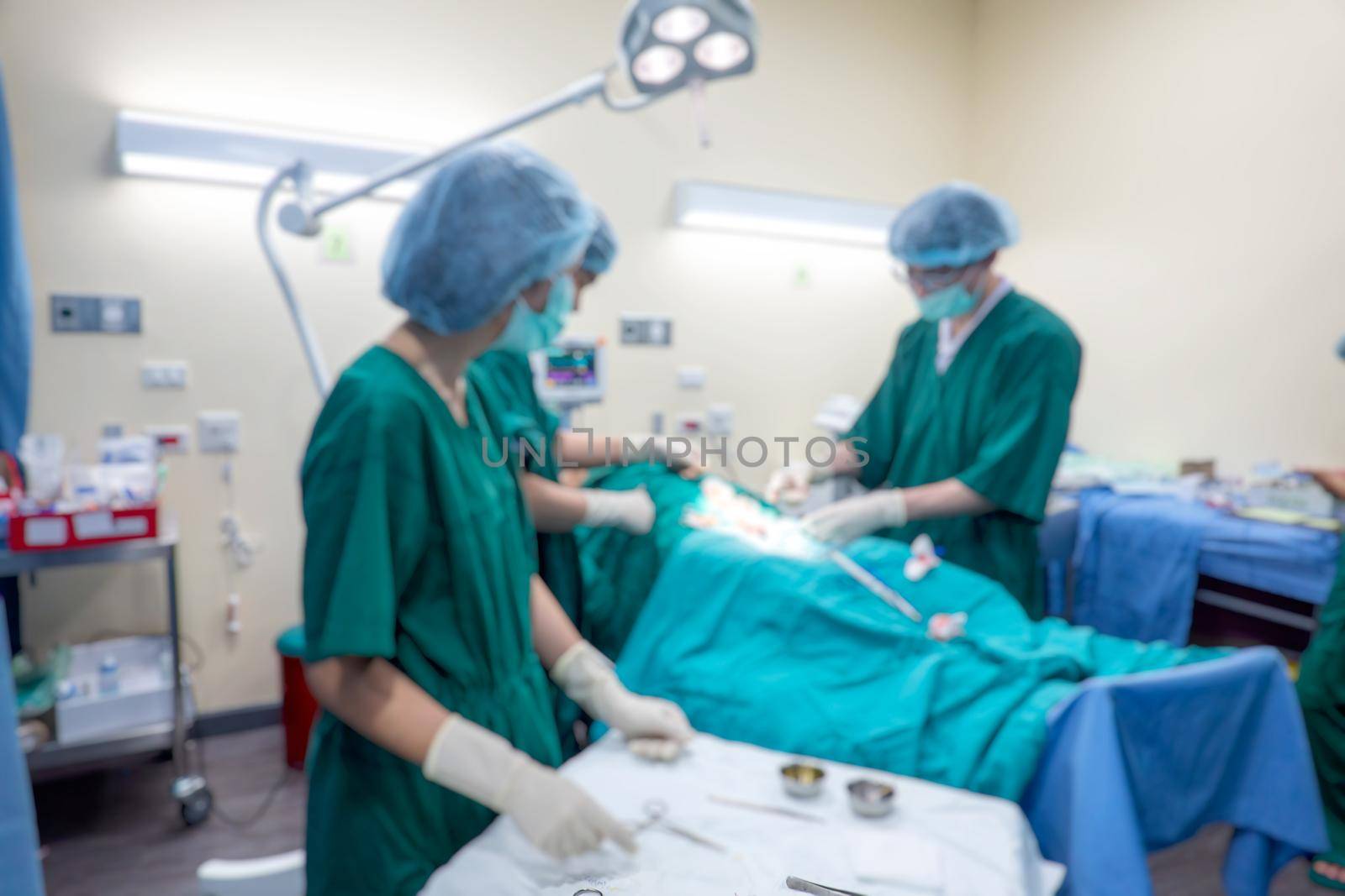 Blurred background of modern operating room at hospital with Group of surgeons in operating room with surgery equipment. Modern medical background by chuanchai