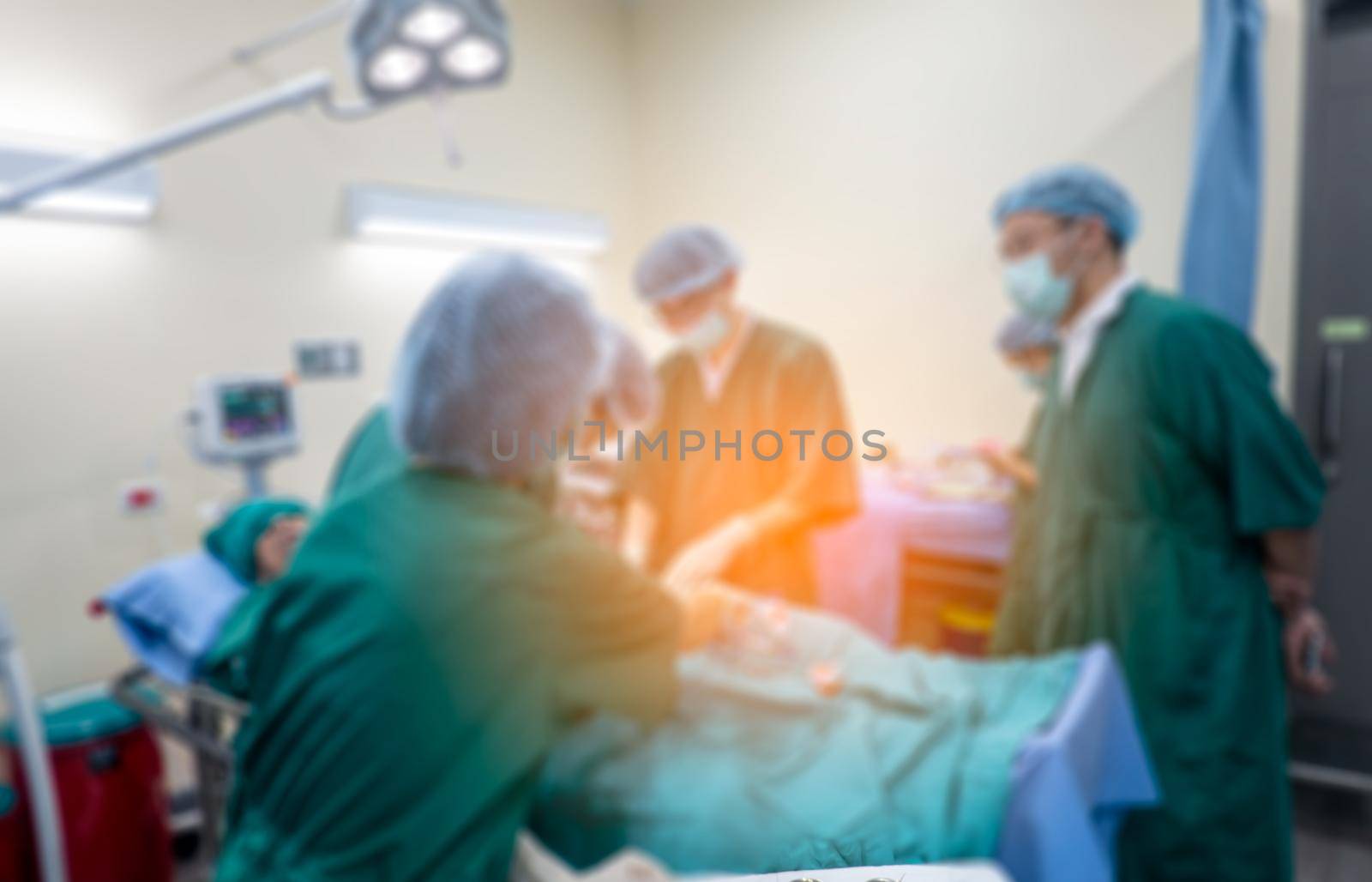 Blurred background of modern operating room at hospital with Group of surgeons in operating room with surgery equipment. Modern medical background by chuanchai