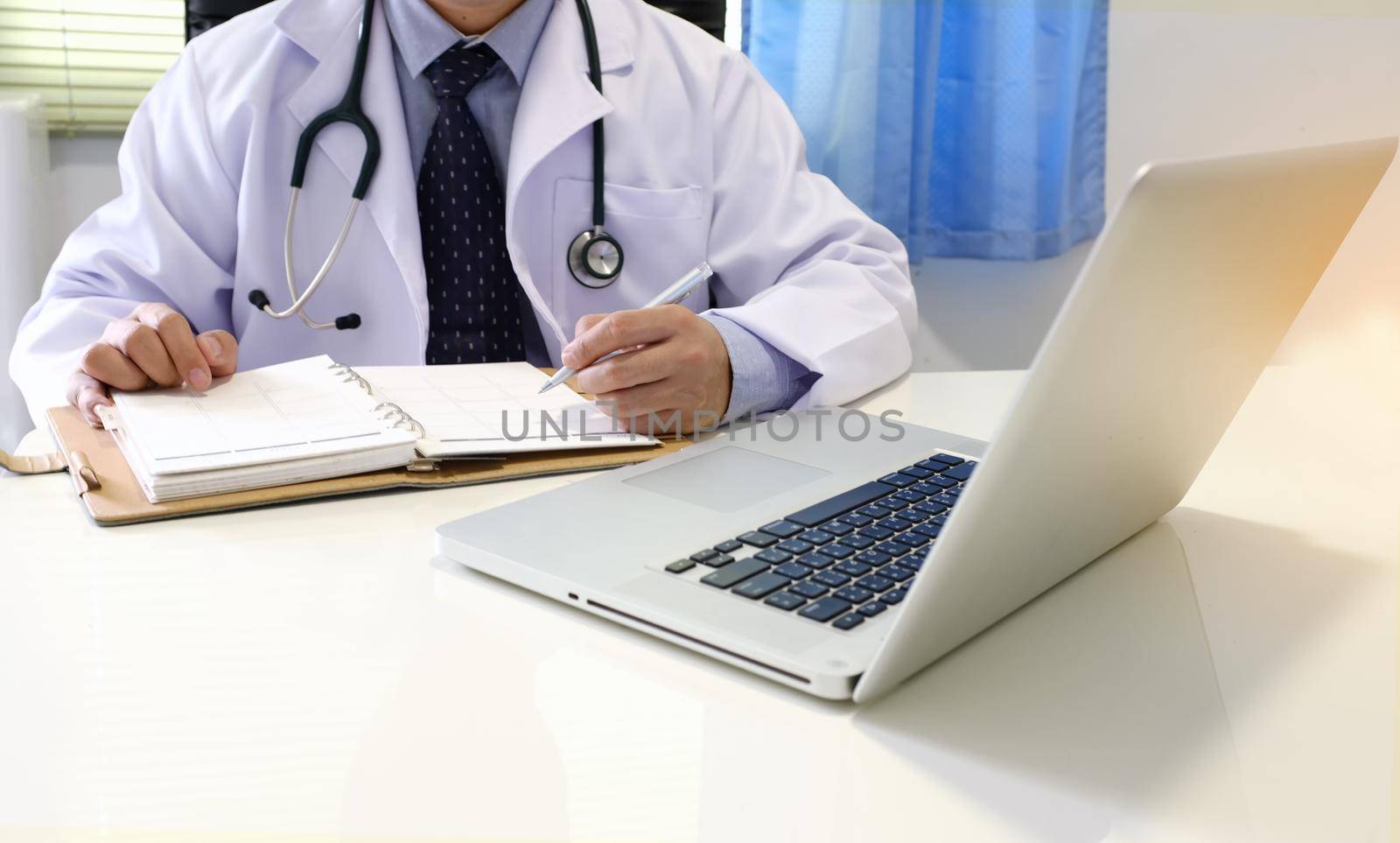 Midsection of Doctor With Arms Crossed Holding Stethoscope with copy space. Healthcare and medical concept.