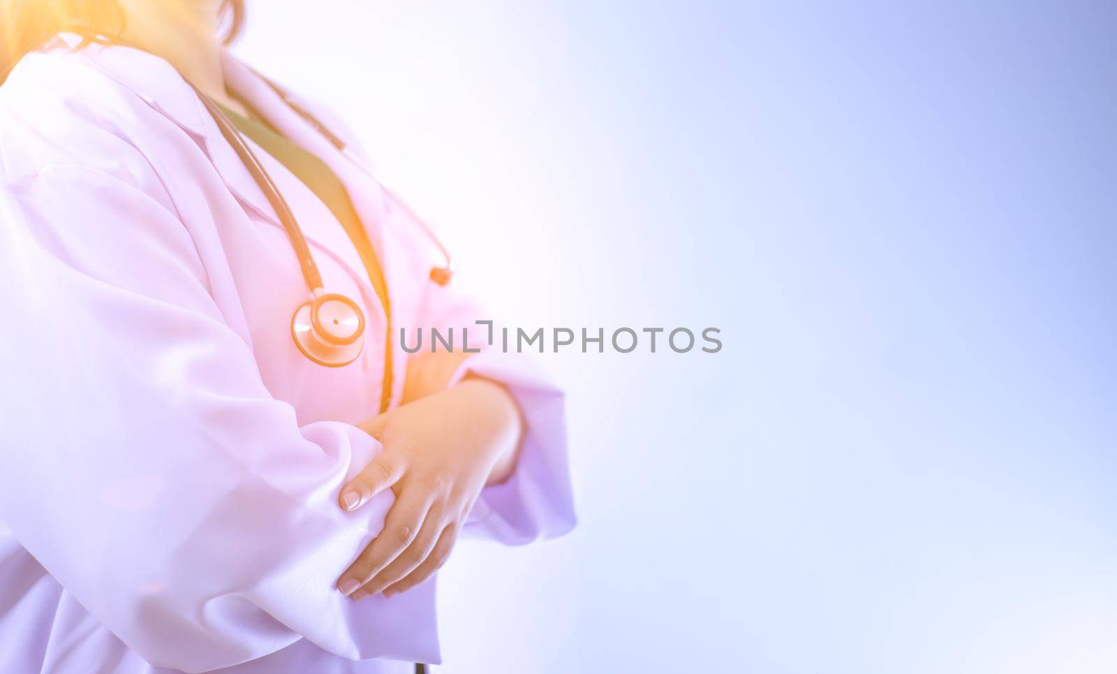 Midsection of Doctor With Arms Crossed Holding Stethoscope with copy space. Healthcare and medical concept. by chuanchai