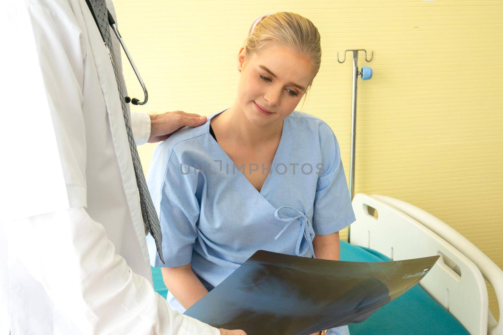 Doctor explaining lungs x-ray to women patient in clinic or Doctor in the office examining an x-ray and discussing with a patient