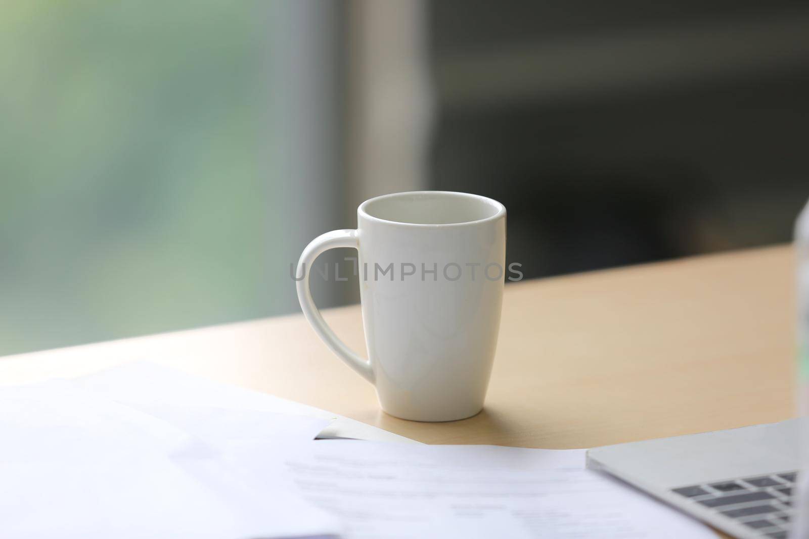 white coffee cup on office desk by chuanchai
