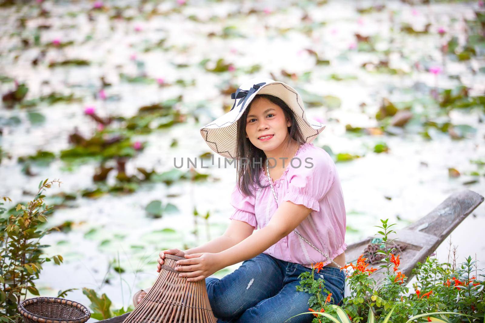 Portrait Of Smiling Young Woman sitting on boat at Outdoors by chuanchai