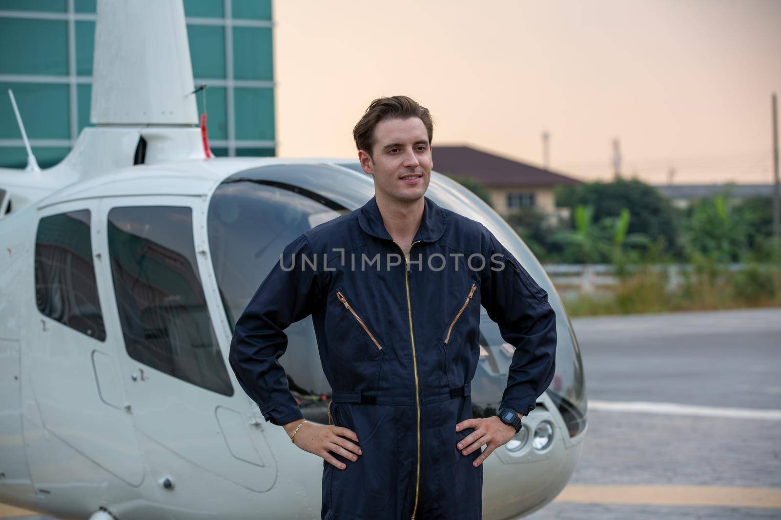 Commercial man pilot in technician suit standing in front of helicopter after check and maintenance engine	 by chuanchai