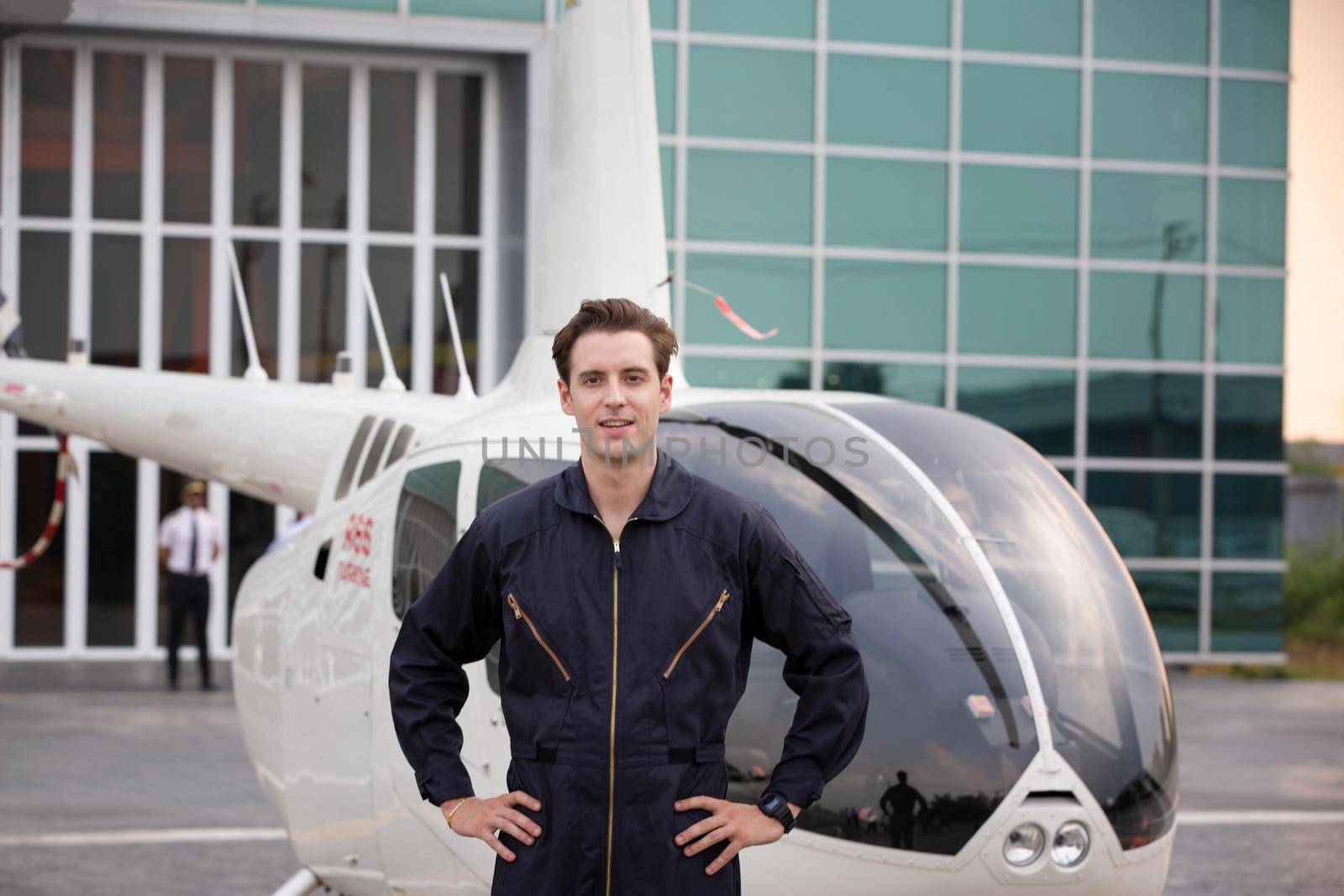 Commercial man pilot in technician suit standing in front of helicopter after check and maintenance engine	 by chuanchai