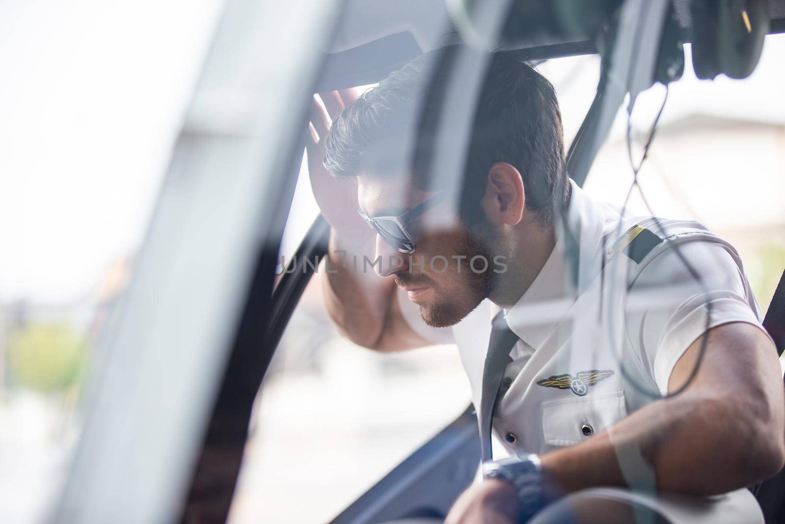 Shot of a mature Helicopter pilot using a headset while traveling in a helicopter, Business people traveling by helicopter