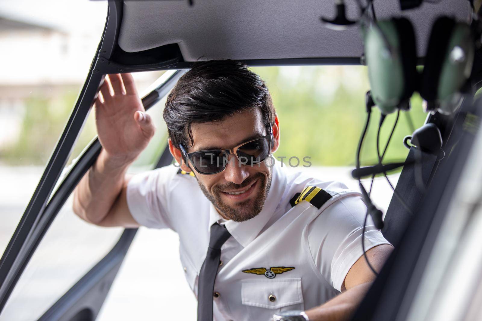 Shot of a mature Helicopter pilot using a headset while traveling in a helicopter, Business people traveling by helicopter